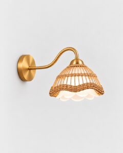 Intreccio wall lamp with a woven rattan shade on a curved brass arm by Hilykan