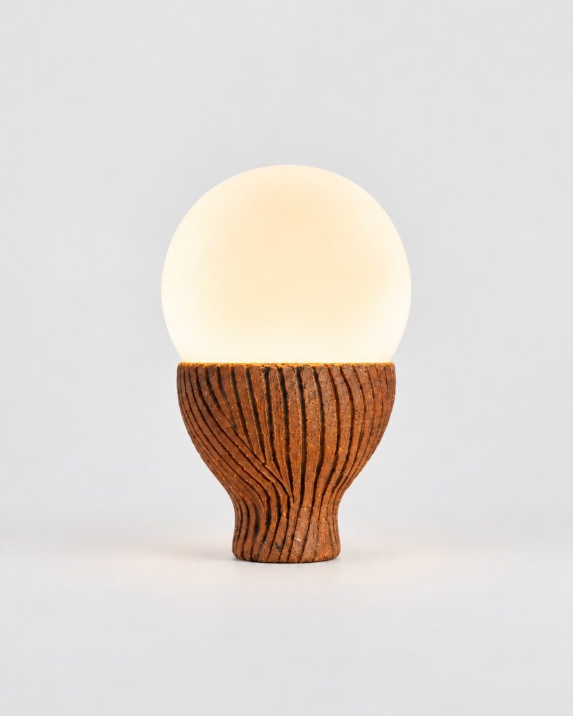 Solbulb table lamp with an opal glass globe on a ridged ceramic base by Hilykan